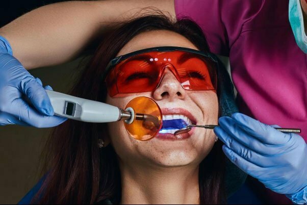 emale dentist treating patient close up photo